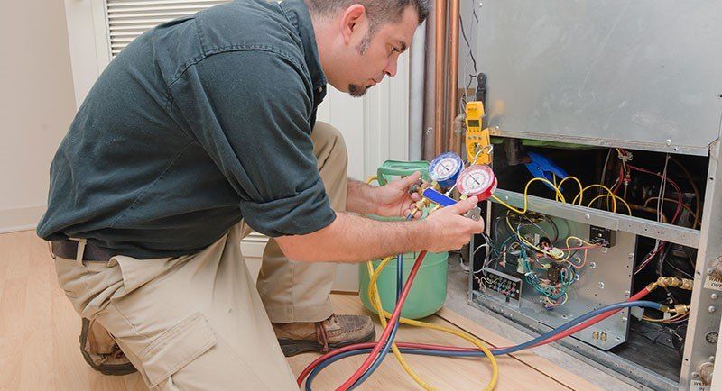 Man Checking the Air Conditioner — Manheim, PA — Garden Spot Mechanical, Inc. Man Checking the Air Conditioner — Manheim, PA — Garden Spot Mechanical, Inc.