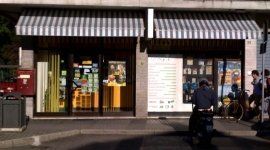 vista dall’esterno di una tabaccheria e un uomo in motorino in sosta