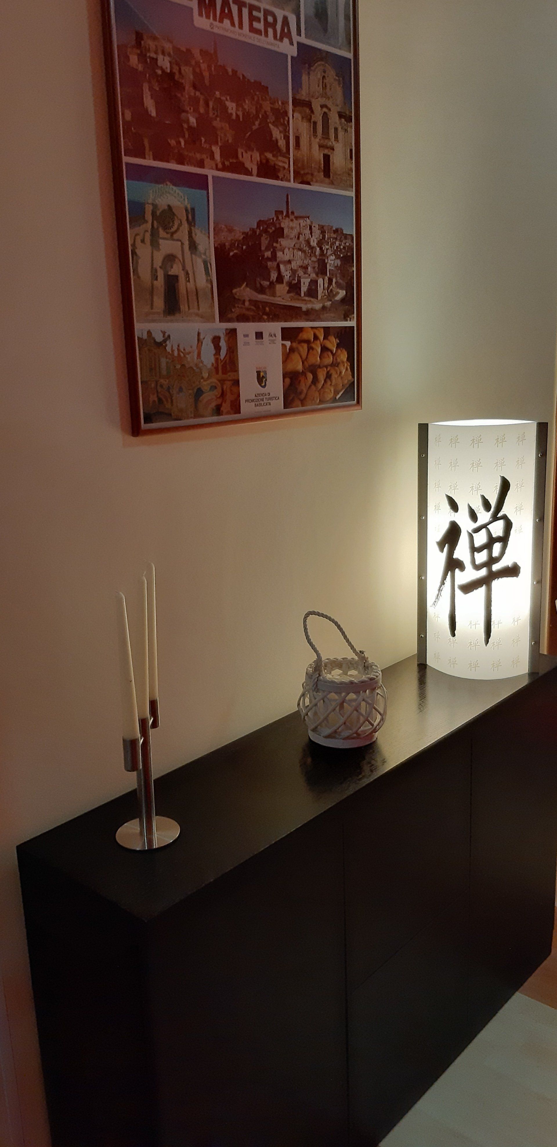 Un mobile nero con oggetti decorativi: una lampada con la scritta