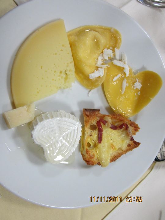 Piatto con formaggio, ravioli e pane.