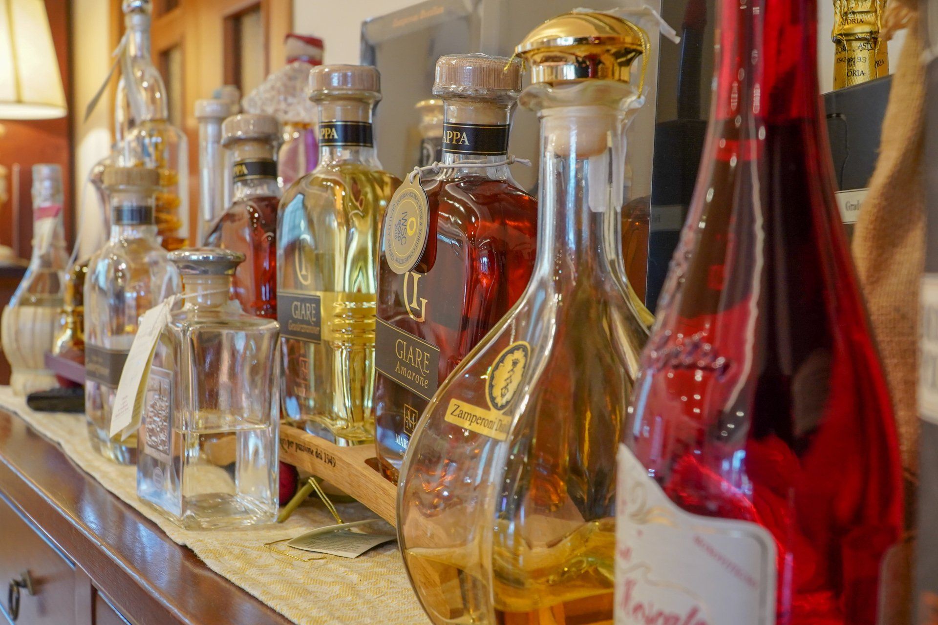 Bottiglie di tequila di vari colori e stili, disposte su un bancone.