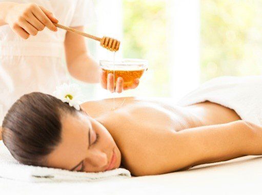 Eine Frau bekommt eine Rückenmassage mit Honig.