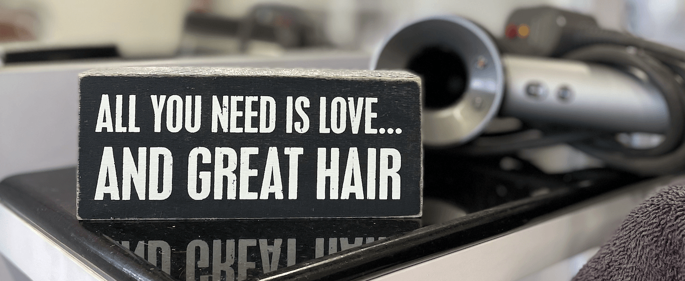 A sign that says all you need is love and great hair