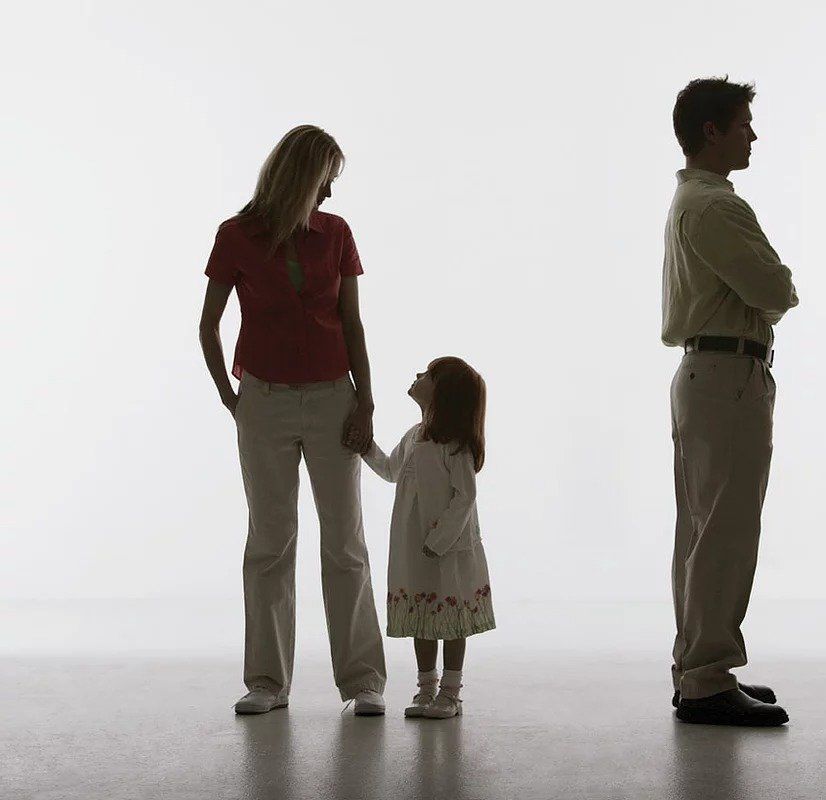 A man and a woman standing next to a little girl