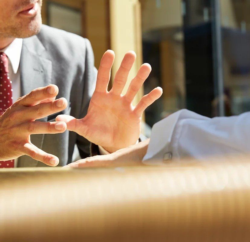 A man in a suit and tie is talking to another man