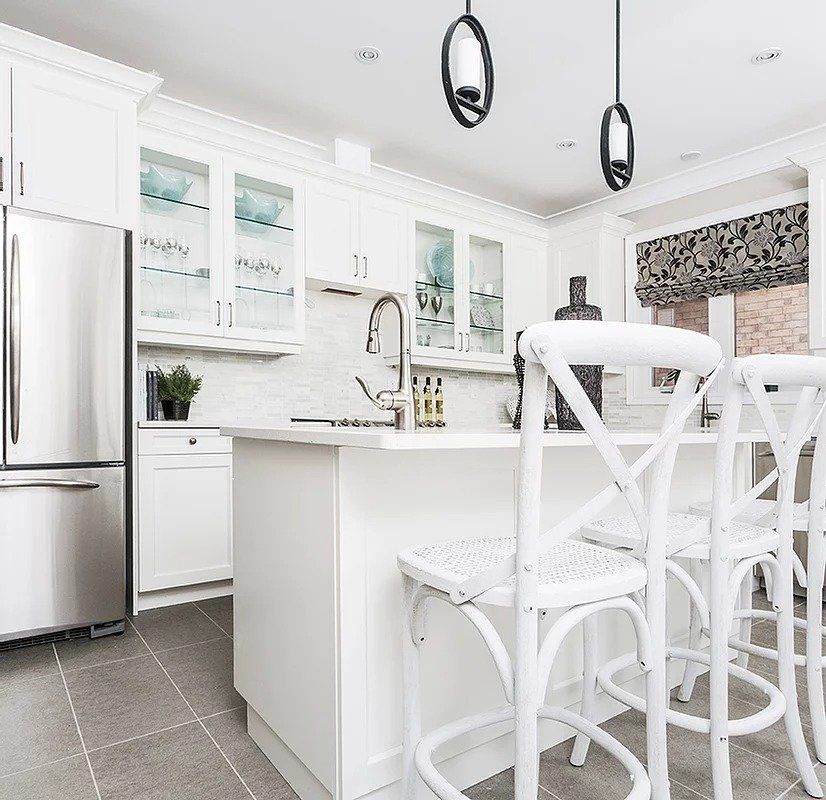 A kitchen with white cabinets and stainless steel appliances