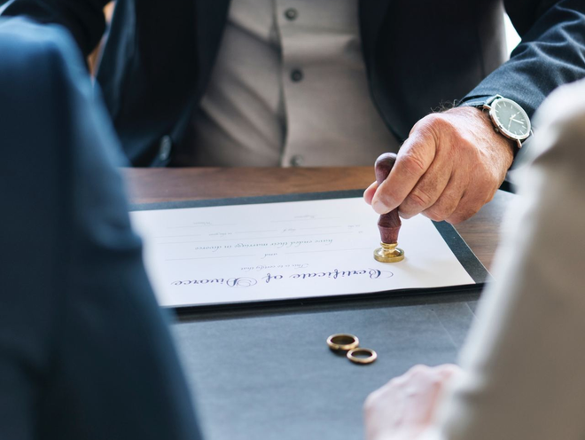 A man is stamping a document with a wax seal.