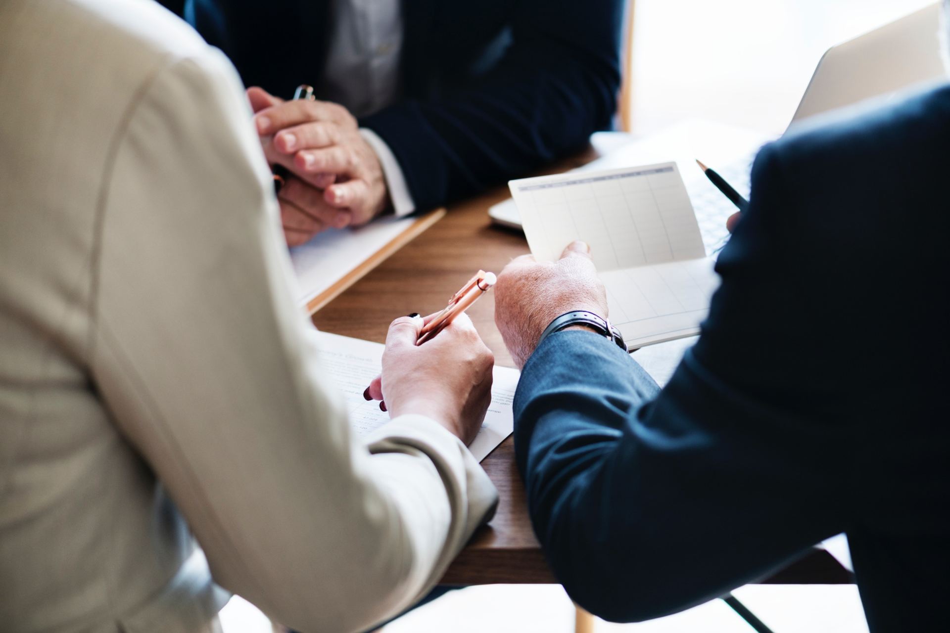 A group of people are sitting at a table having a meeting.