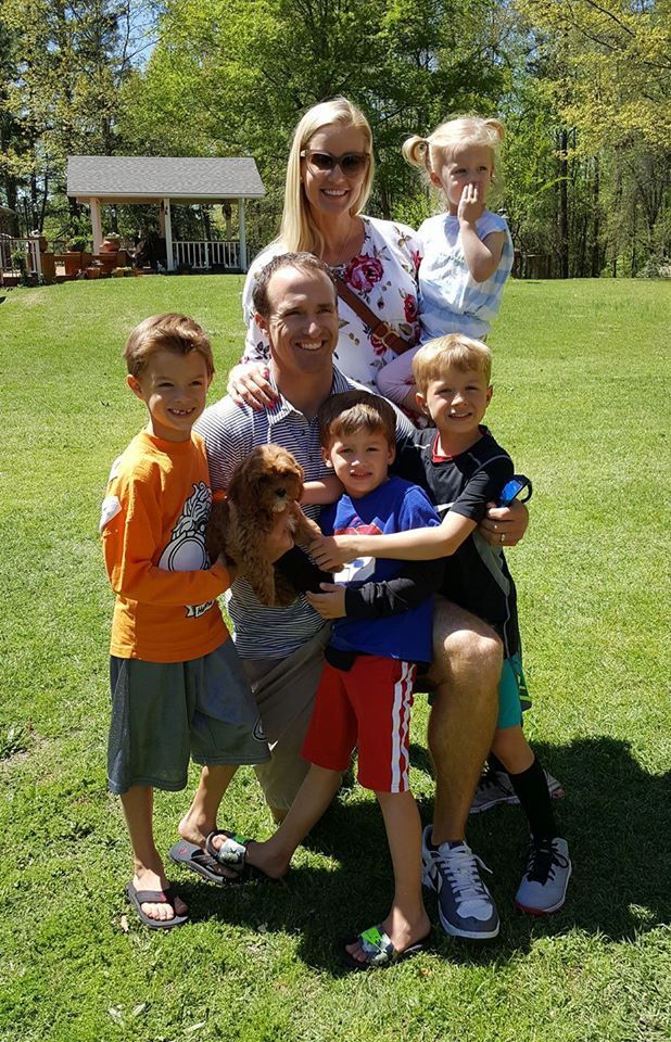 A family is posing for a picture in a park.