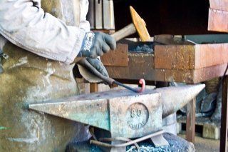 artigiano con incudine e martello
