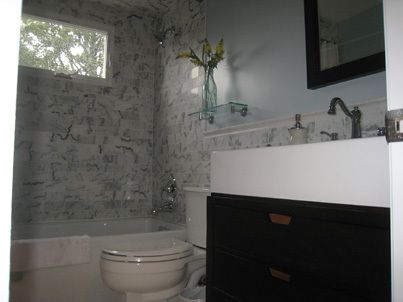 new cabinetry, tile, and toilet in remodeled bathroom