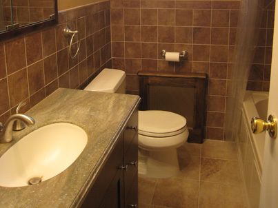 new sink, countertops, toilet, and tiles in remodeled bathroom