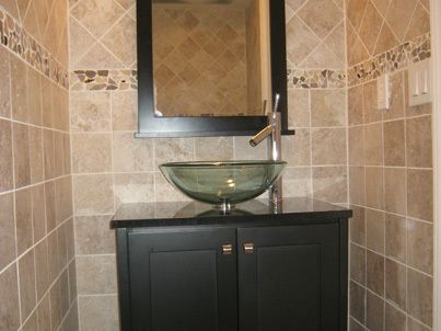 new tiles and vessel sink in remodeled bathroom