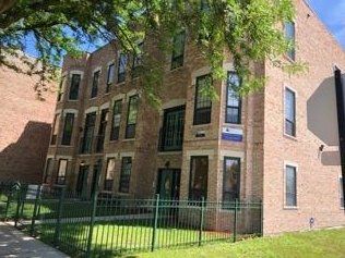 A large brick apartment building with a fence around it.