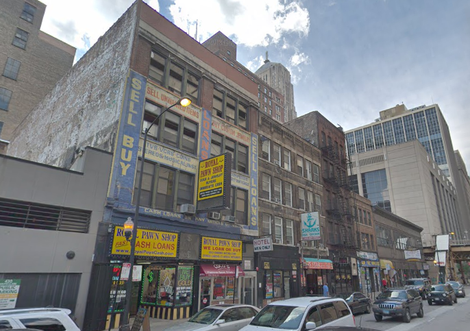 A city street with cars parked in front of a building that says sell buy