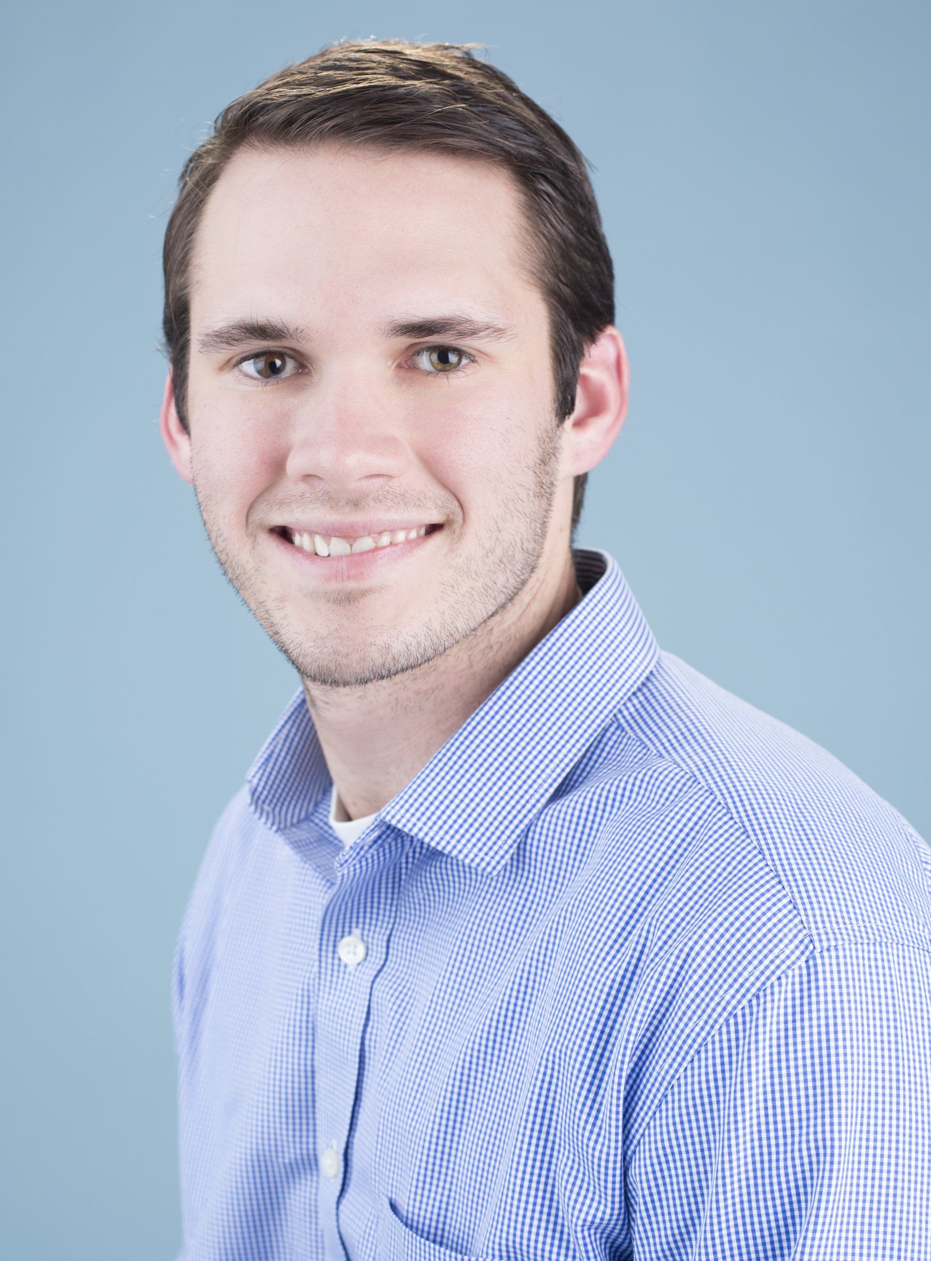 A man in a blue shirt is smiling for the camera