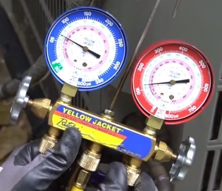 Blue and red pressure gauges on a Yellow Jacket HVAC manifold gauge set