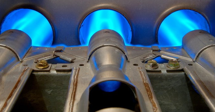Blue gas flames burning in metal burners with a close-up view of a stove top