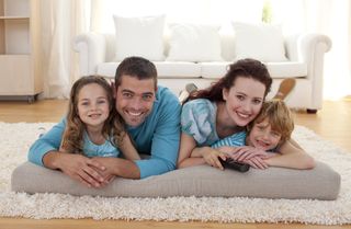 Smiling family on floor in living-room