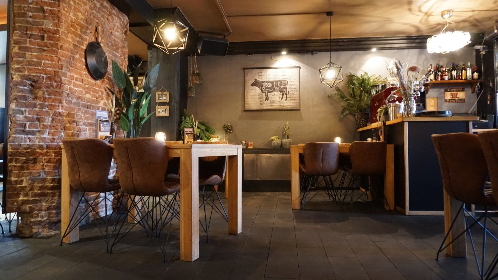 Gezellig, rustiek restaurantinterieur met bakstenen muren, houten tafels, leren stoelen en warme verlichting.