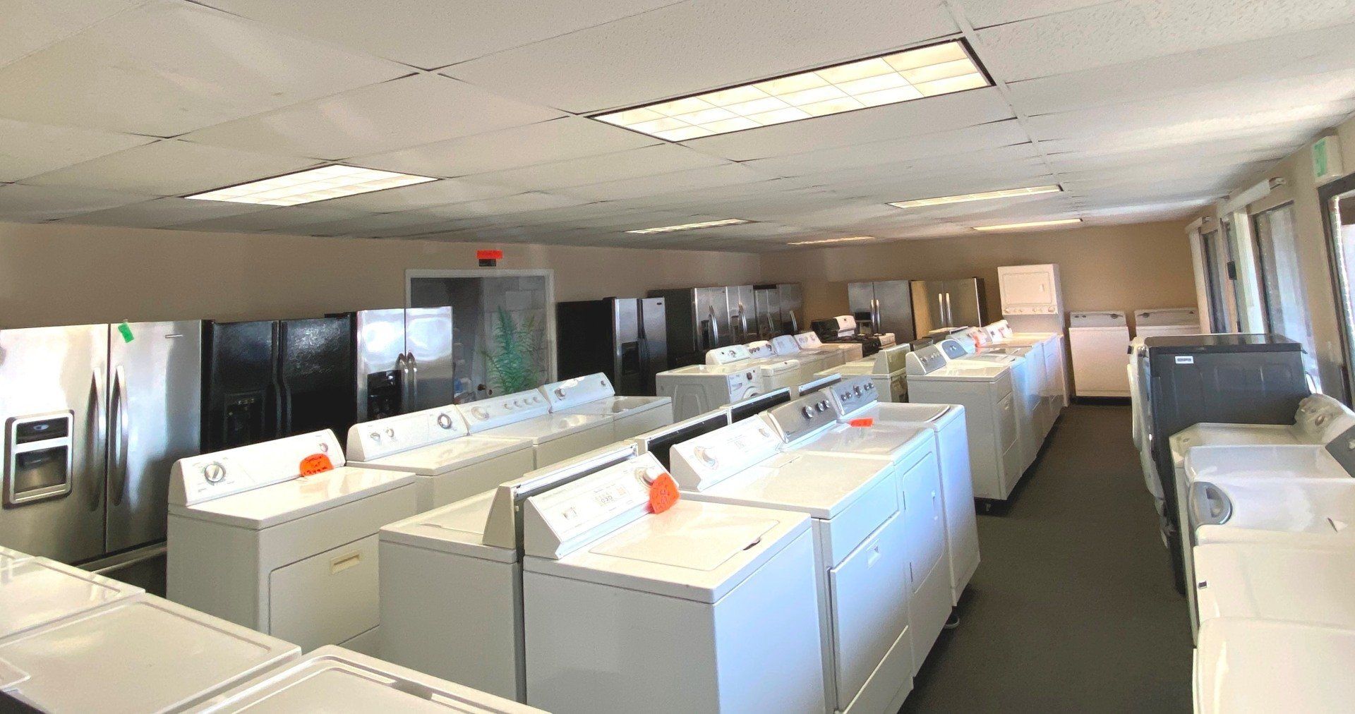 A large room filled with lots of washers and dryers.