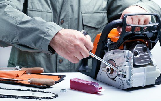 Small Engine Repair — Man Fixing Power Saw in Sunrise Beach, MO