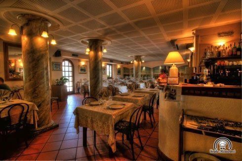 Dei tavoli apparecchiati e vista dell'angolo bar