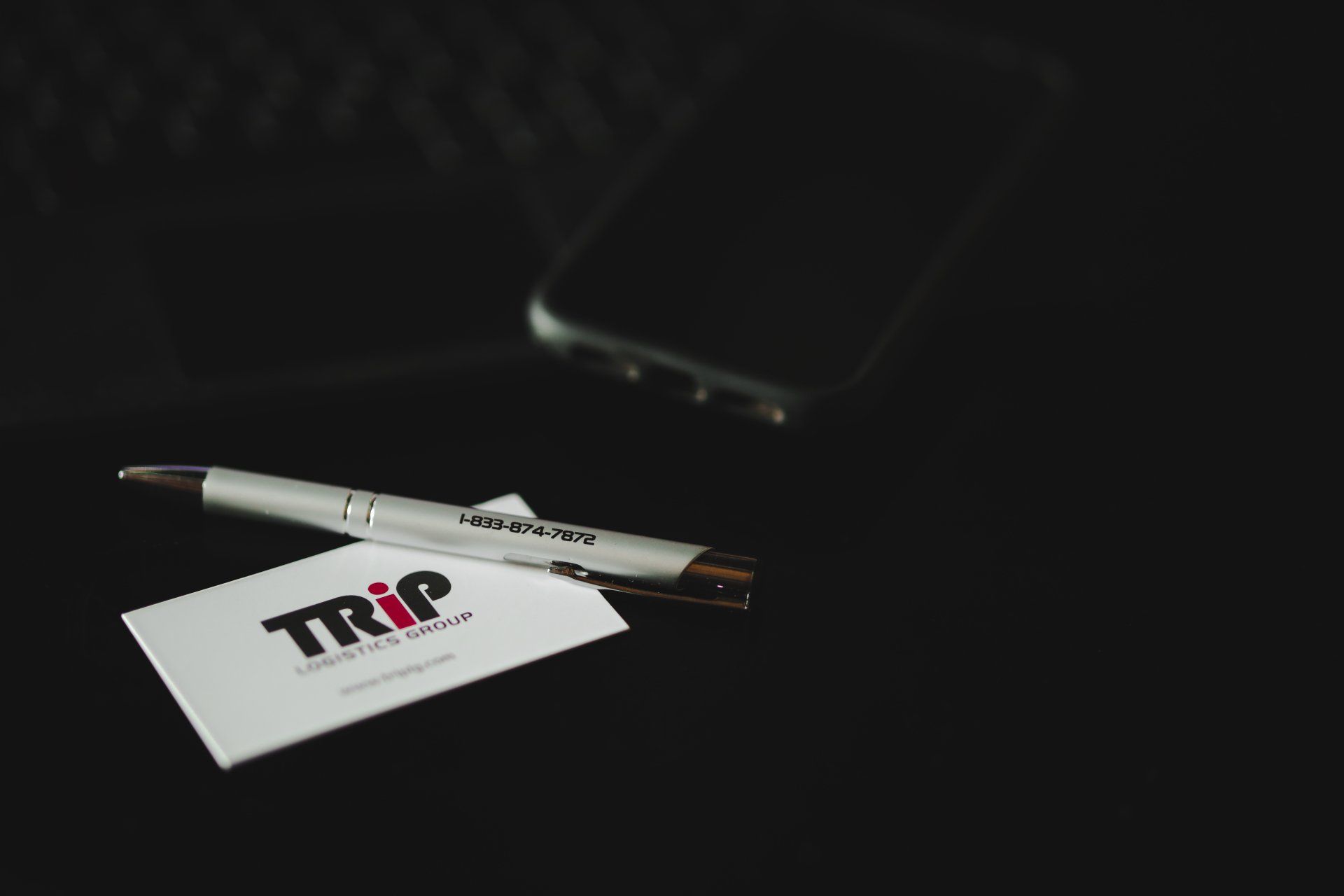 A pen and a business card with the word trip on it