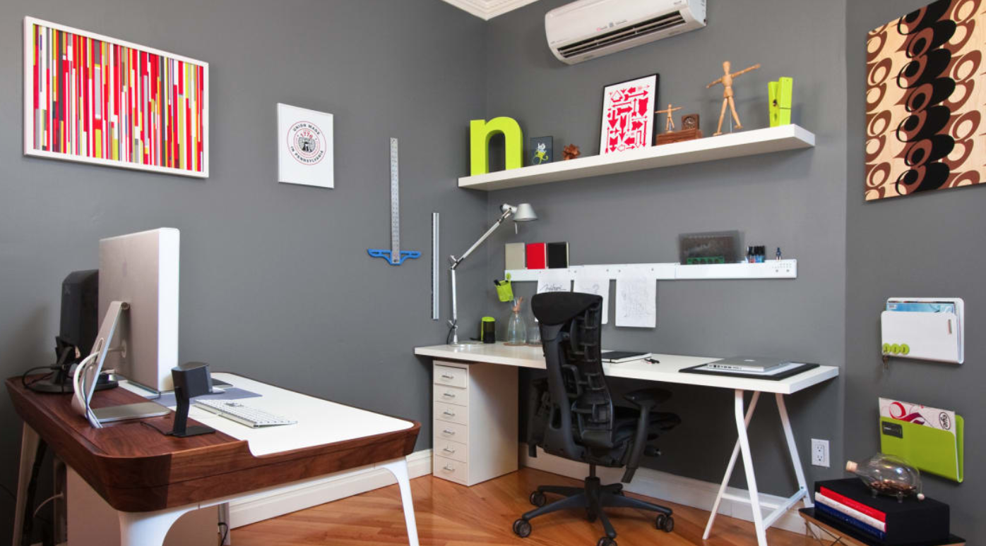 A home office with a desk , chair , computer and shelves.