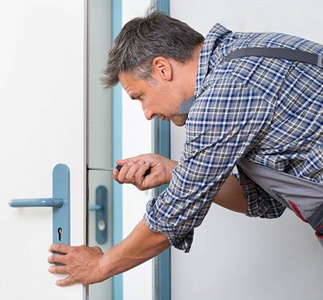 Man Fixing the Door Lock — Durham, NH — H & H Locksmith Man Fixing the Door Lock — Durham, NH — H & H Locksmith