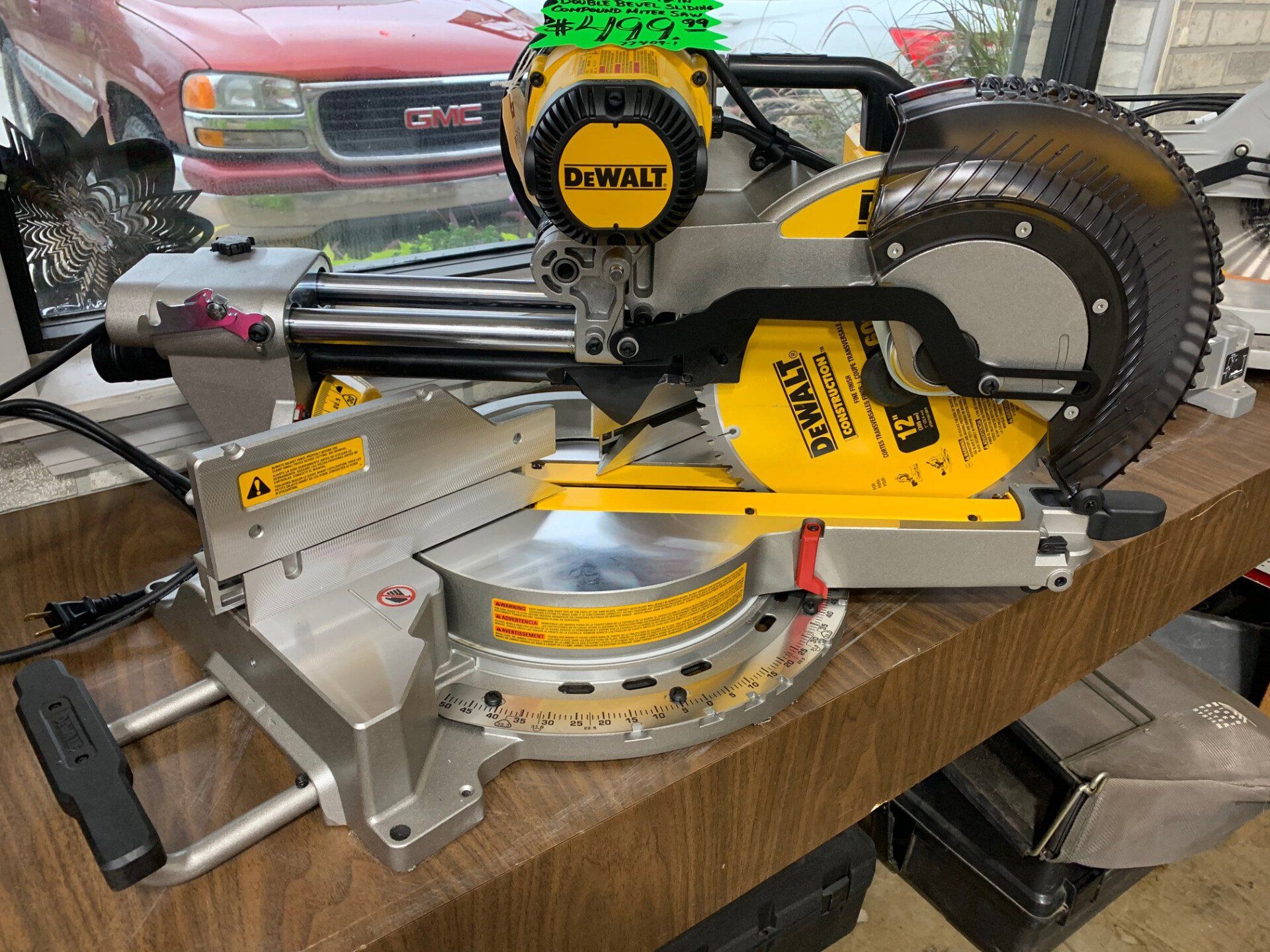 A dewalt miter saw is sitting on a wooden table.