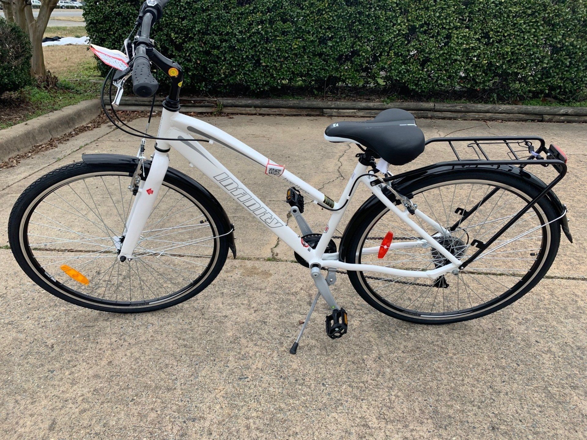 A white bicycle is parked on the side of the road.