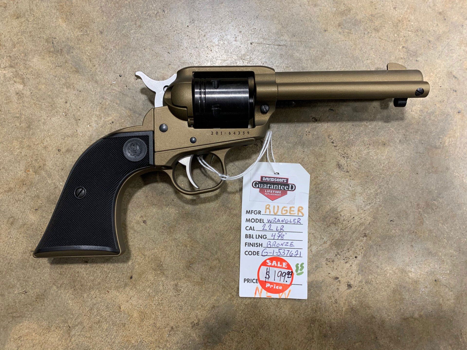 A revolver with a tag attached to it is sitting on a table.