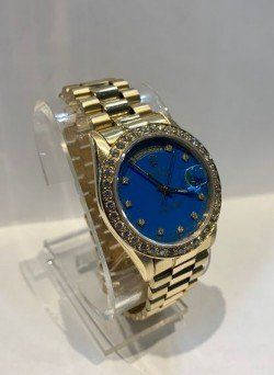 A gold watch with a blue face and diamonds on it
