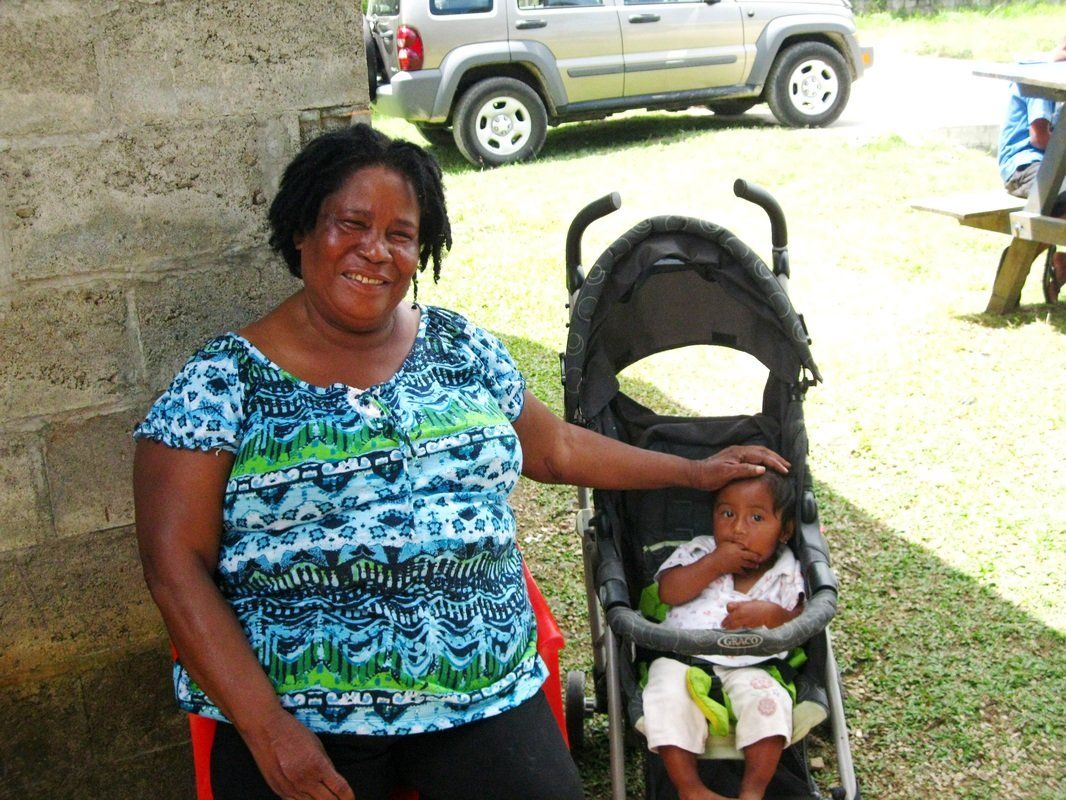 A woman is sitting next to a baby in a stroller
