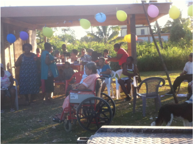A woman in a wheelchair is surrounded by people