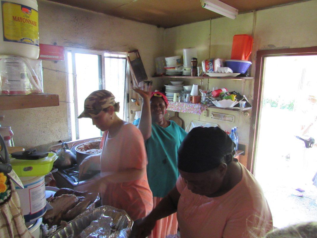 A group of people are standing in a kitchen with a bottle of water on the wall