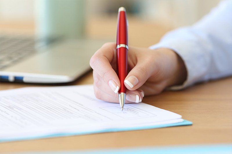 Insurance Aggregator — Lady Signing the Documents in Stronghurst, IL
