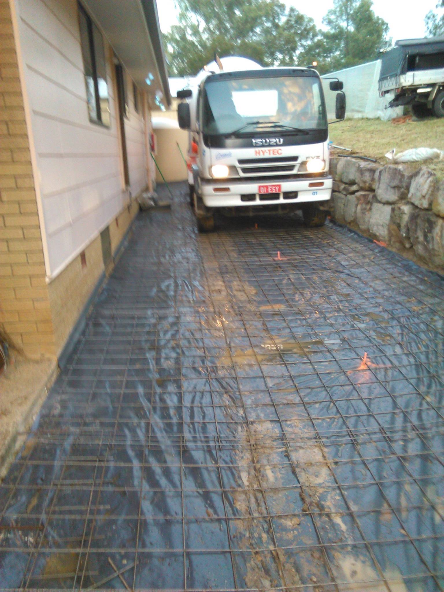 team installing concrete on side of house