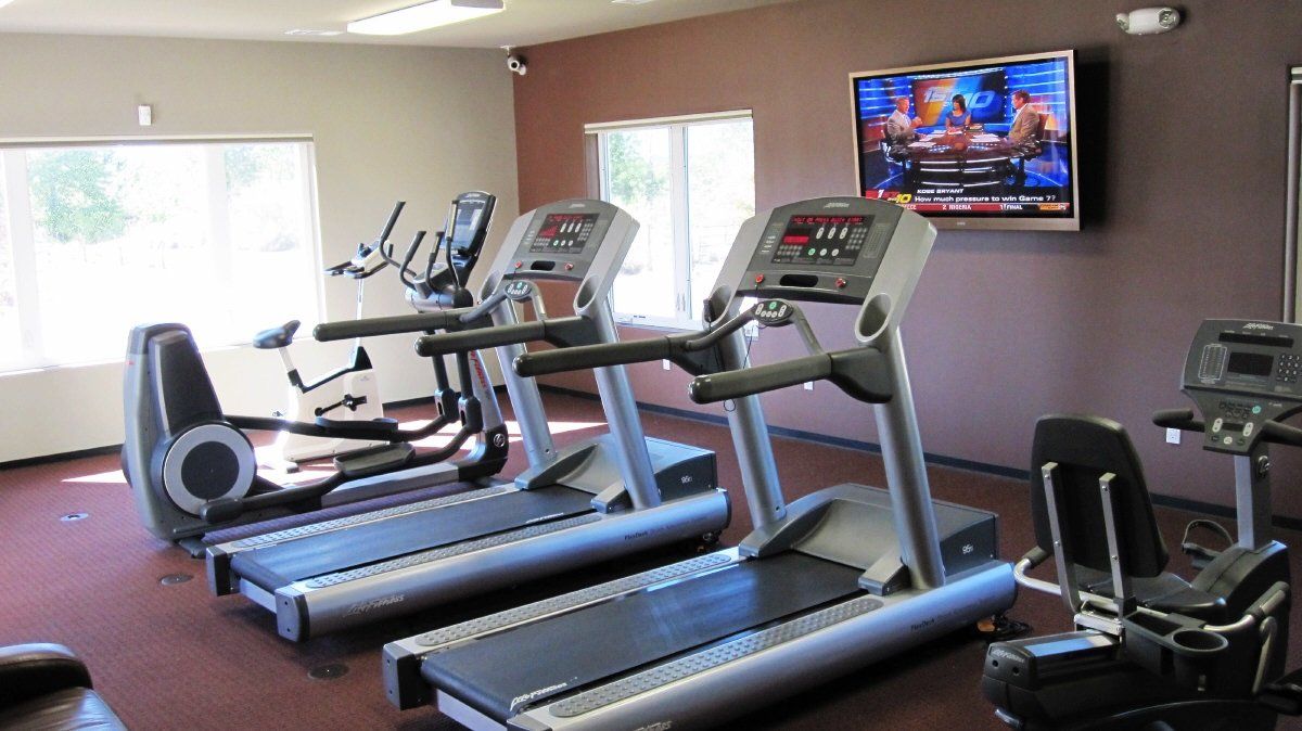 A gym with treadmills and a tv on the wall