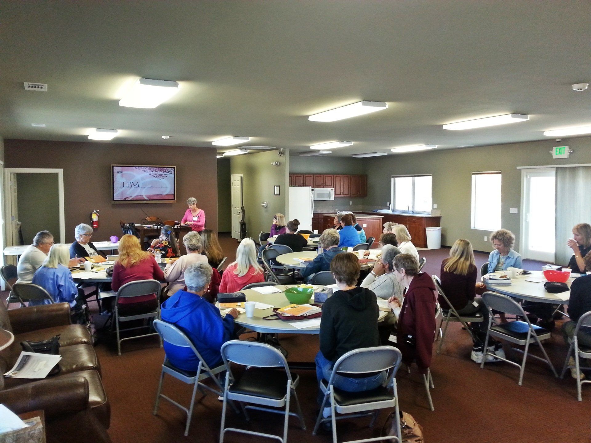 A group of people are sitting at tables in a large room