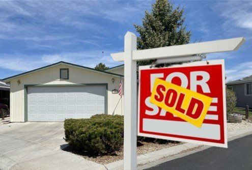 A house with a for sale sign in front of it