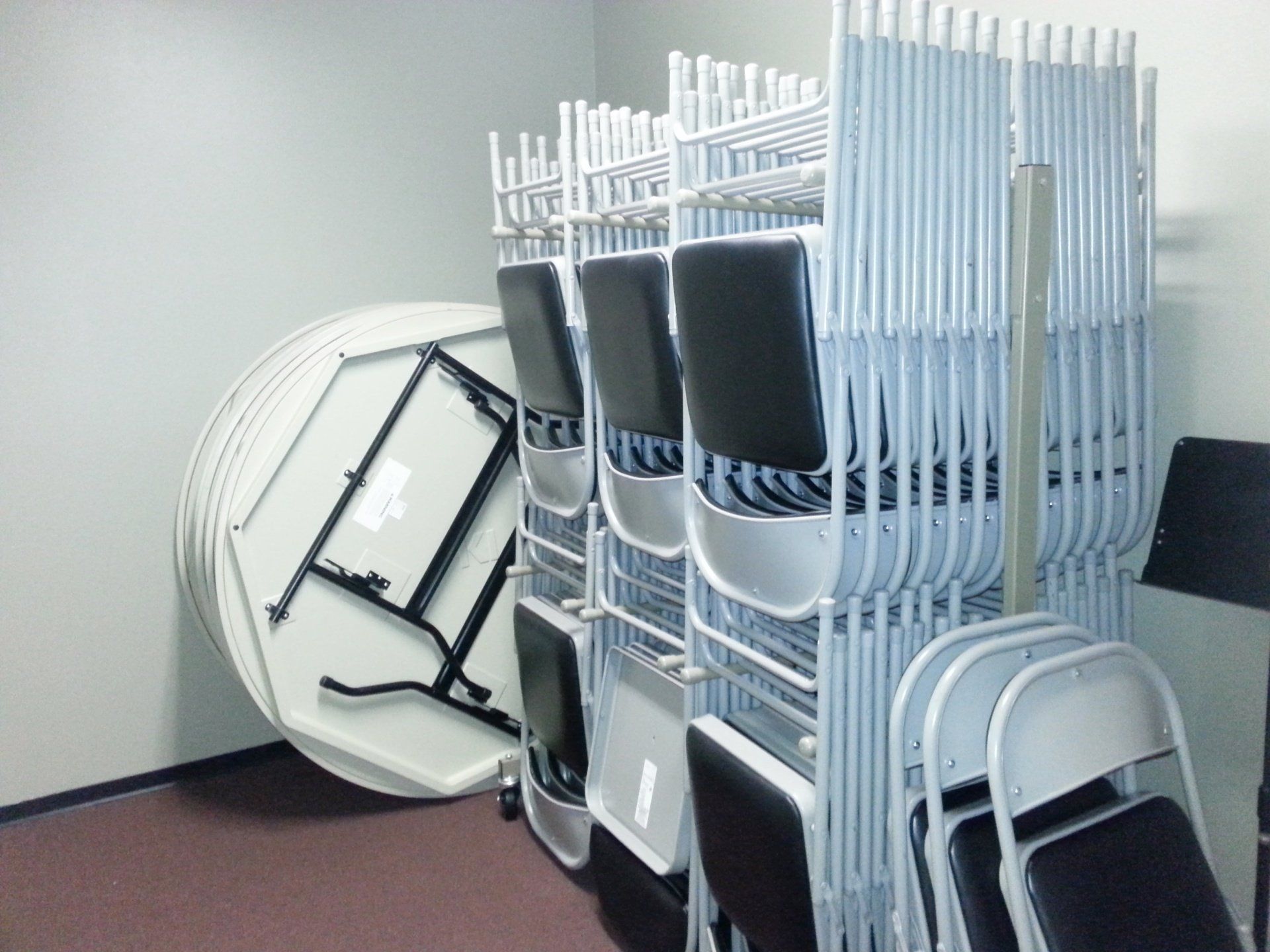 A stack of folding chairs next to a round table