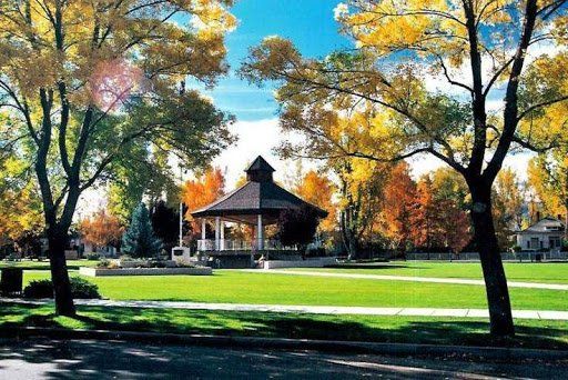 A gazebo in a park with trees in the background