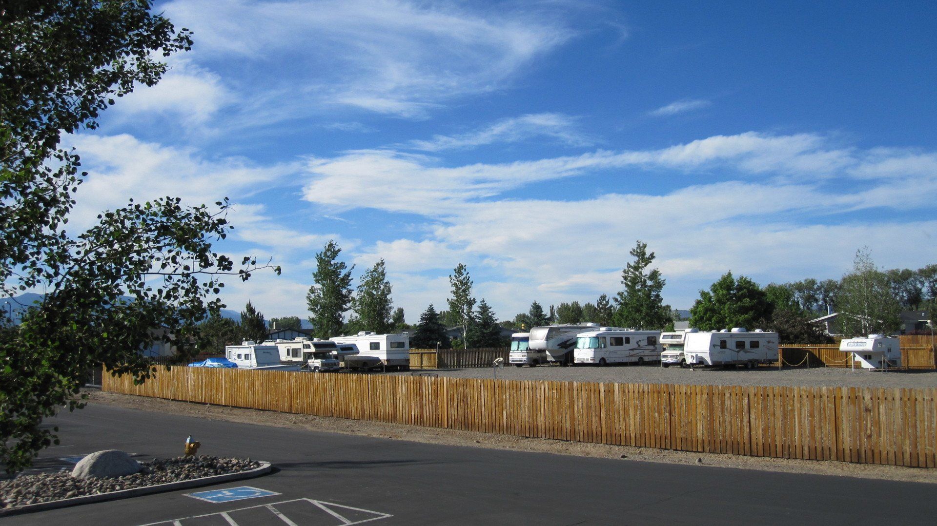 A row of rvs are parked in a parking lot