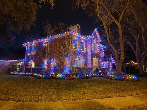 A house is decorated with christmas lights at night