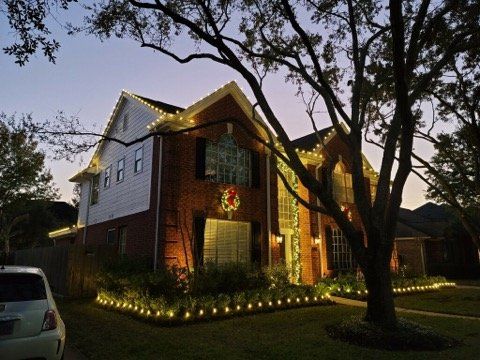 A house is decorated with christmas lights and a wreath