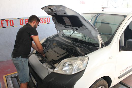 un meccanico verifica motore veicolo