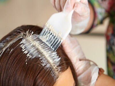 A Girl Applying Hair Color — Hair Care in Souderton, PA A Girl Applying Hair Color — Hair Care in Souderton, PA