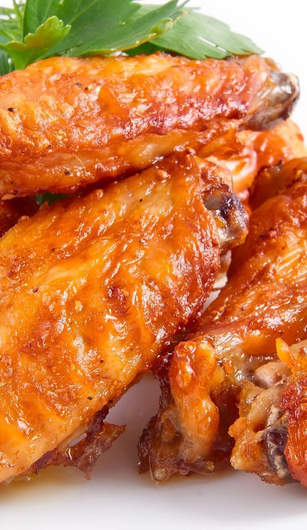 A close up of chicken wings on a white plate.